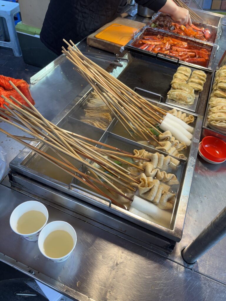 串に刺さったおでんと温かいスープが並ぶ屋台テーブル