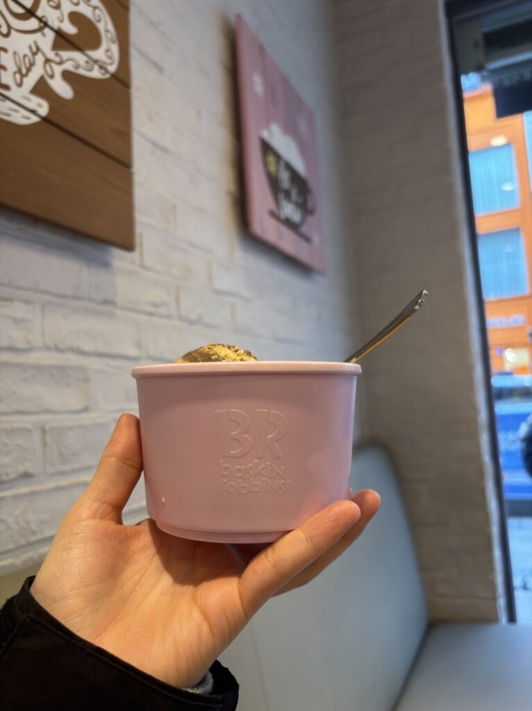 手に持ったピンクのカップ入りアイス